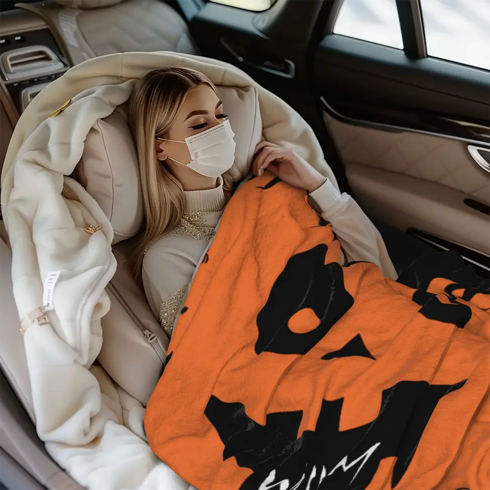 Custom Halloween blanket featuring a pumpkin face design, ideal for staying warm during road trips or outdoor activities.