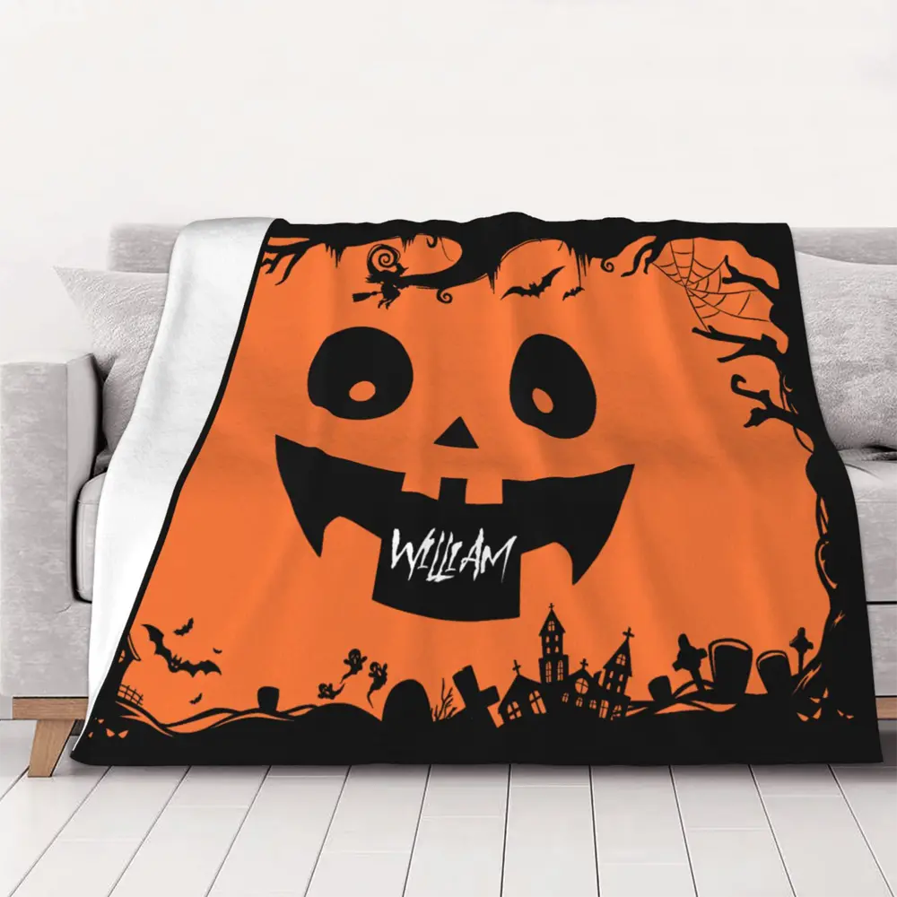 Personalized Halloween pumpkin face blanket displayed on sofa, featuring soft flannel and cozy black and orange festive motifs.