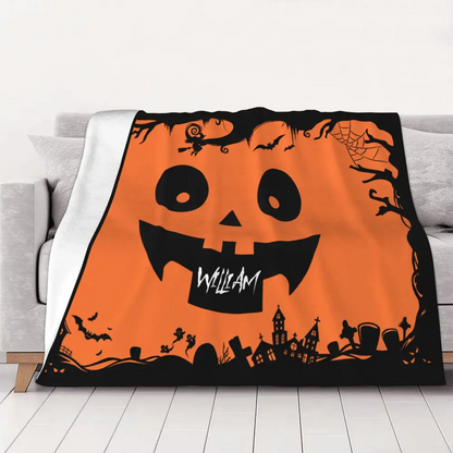 Personalized Halloween pumpkin face blanket displayed on sofa, featuring soft flannel and cozy black and orange festive motifs.