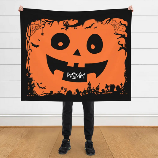 Halloween-themed flannel blanket with personalized name and pumpkin face design in orange and black.